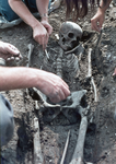 830293 Afbeelding van het blootleggen van een skelet door archeologen tussen de opgravingen van de restanten van het ...